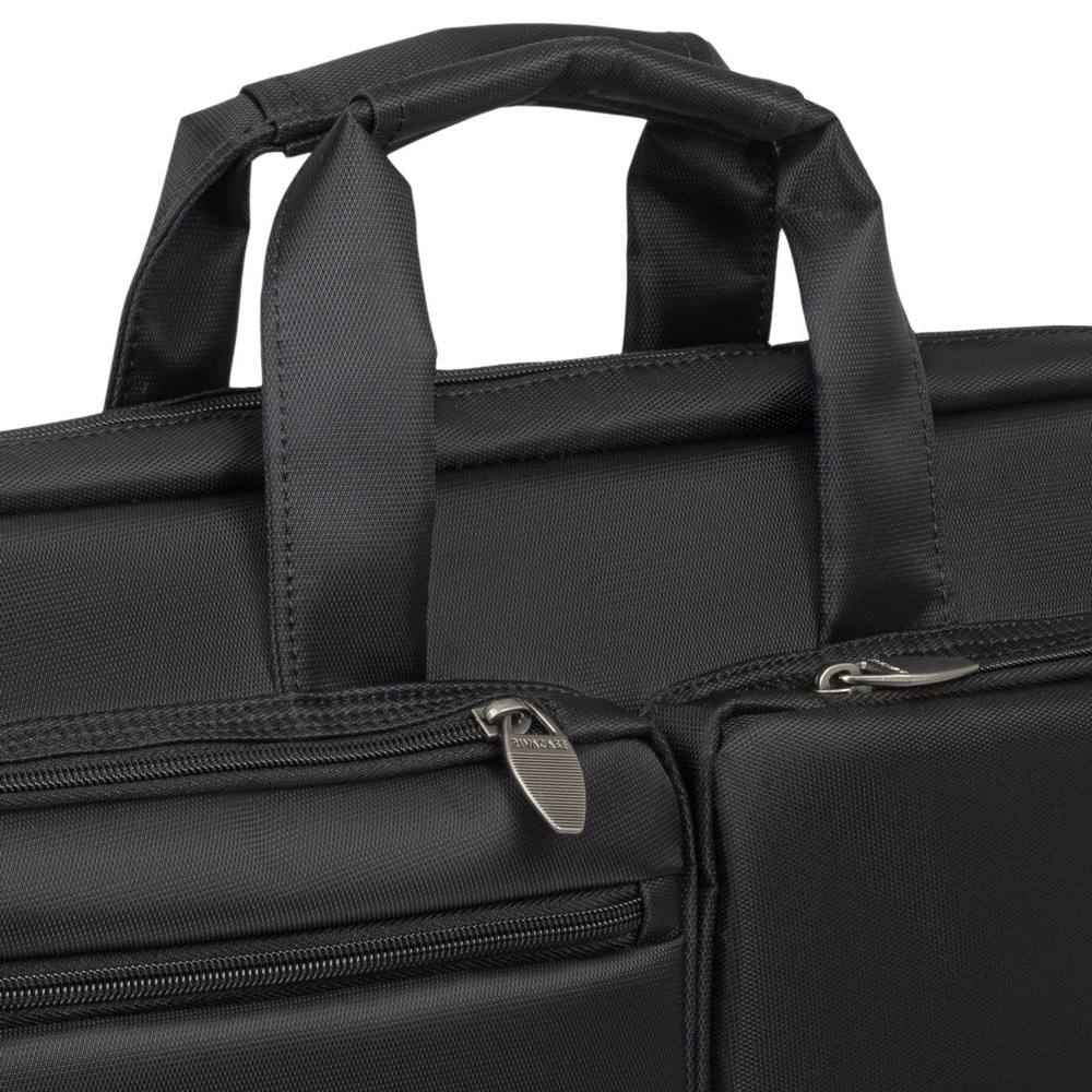 Primo piano di una borsa per laptop nera con cerniere e manici.