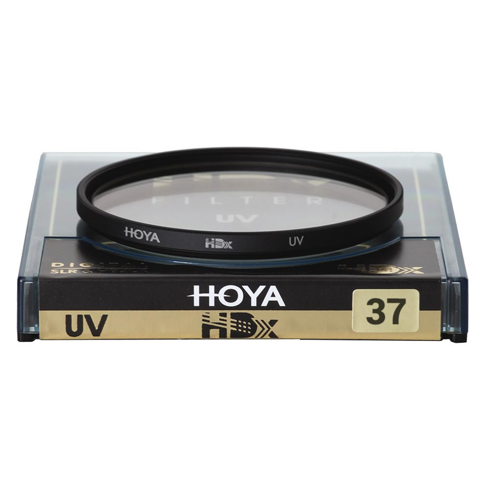 Een Hoya UV-filter, 37 mm, ligt in zijn doorzichtige plastic hoes op een zwart-gouden doos.