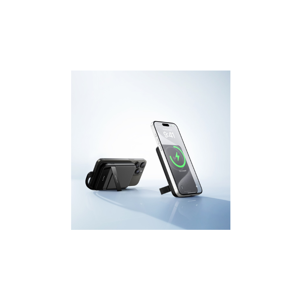 Czarny smartfon ze wskaźnikiem ładowania stoi na uchwycie. Obok leży inny smartfon.