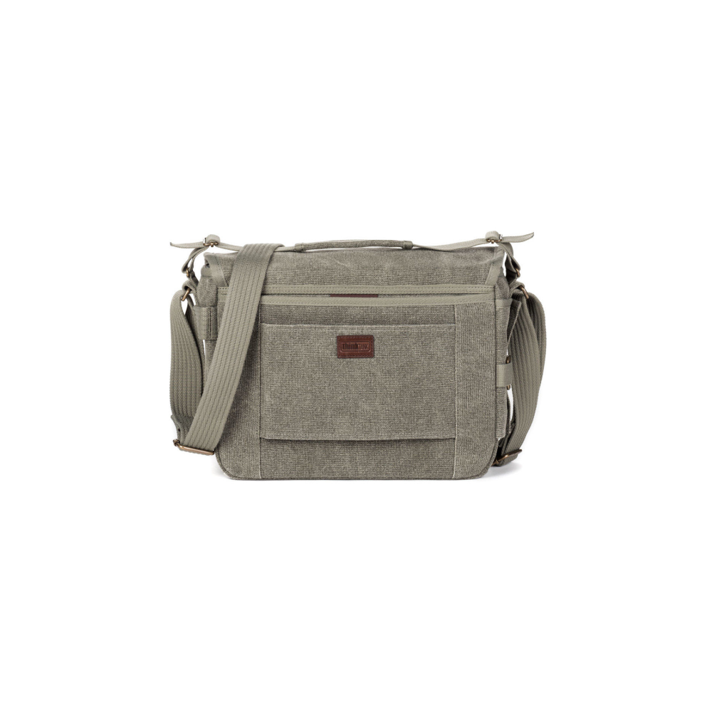 A grey canvas messenger bag with a brown leather tag, isolated on white.