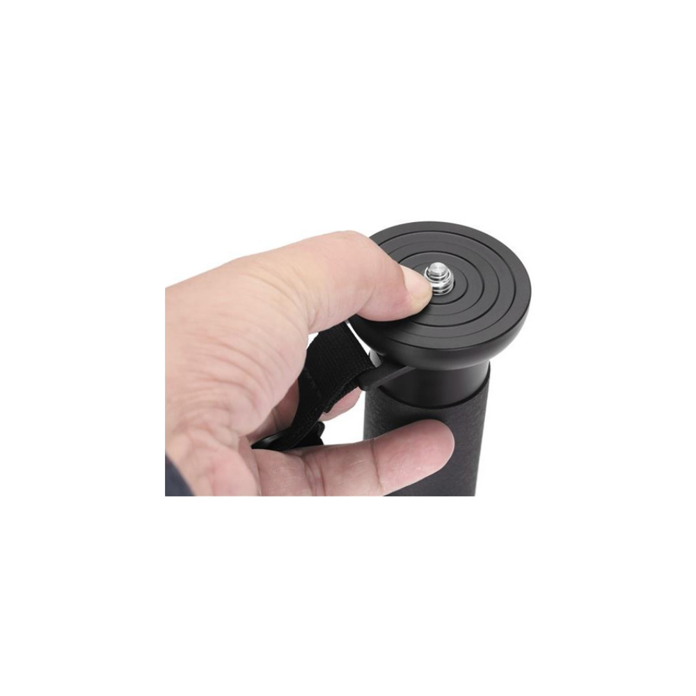 A hand holds a black camera tripod grip with a strap.