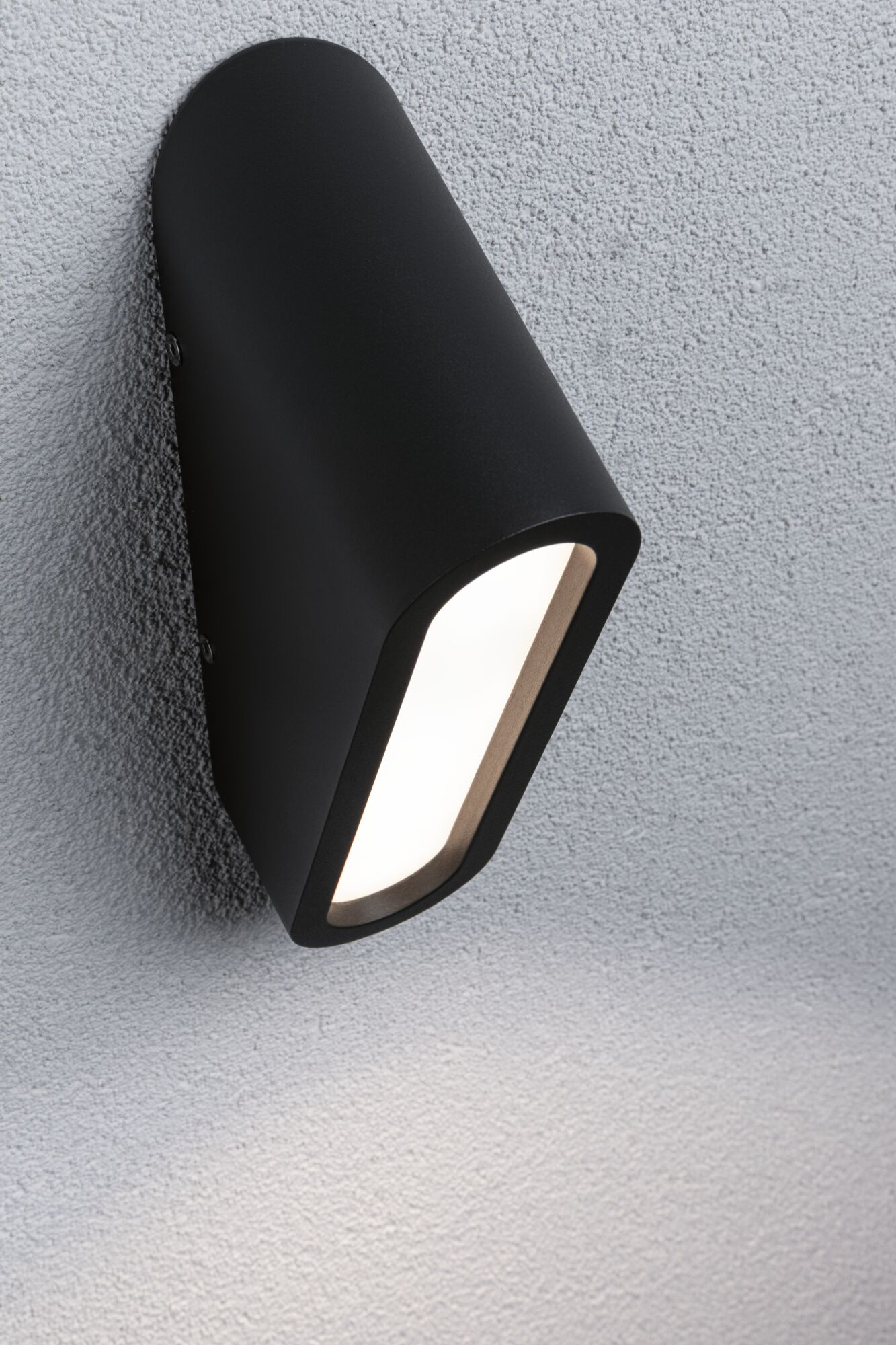 Eine schwarze Wandleuchte mit hellem Licht leuchtet auf einer strukturierten Wand.