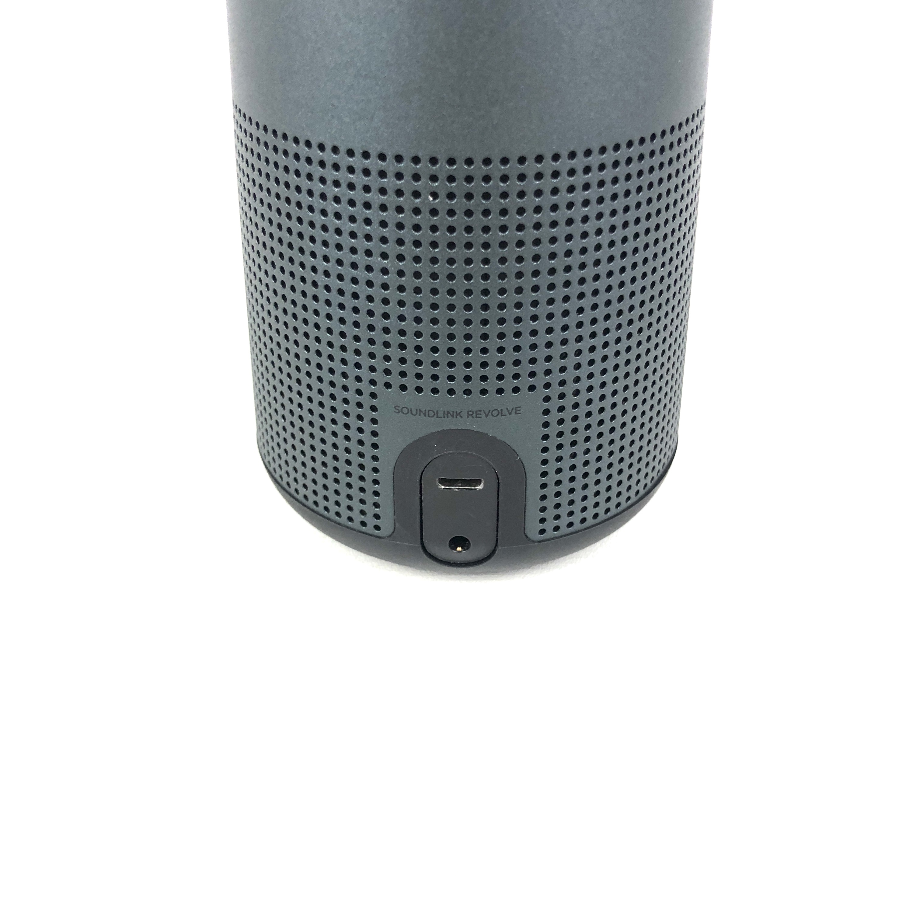 Grauer Lautsprecher mit perforierter Oberfläche und USB-Anschluss.