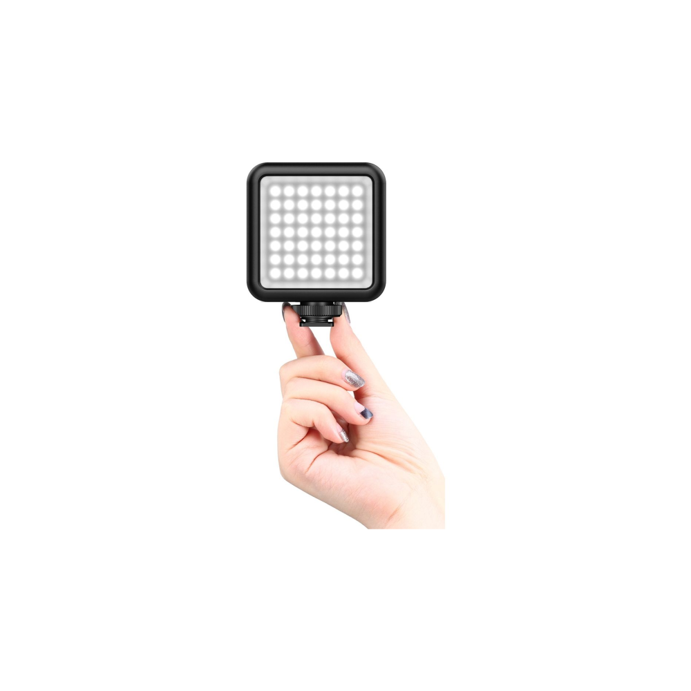 A hand holds a small square LED light with many lights.