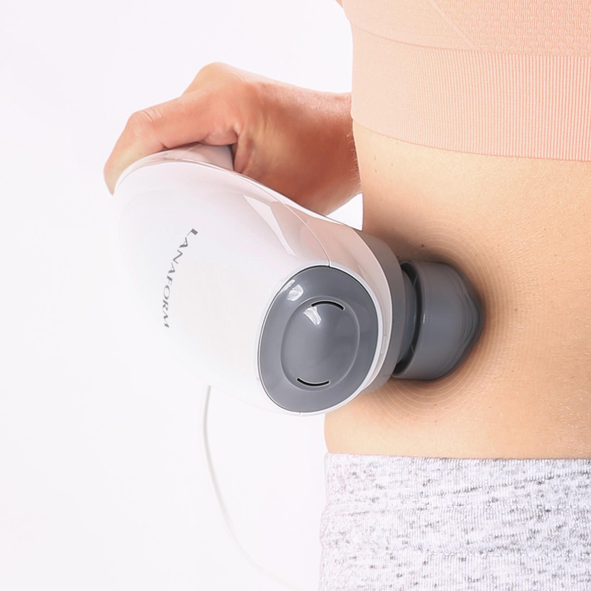 A hand holds a white and gray massager being applied to skin.