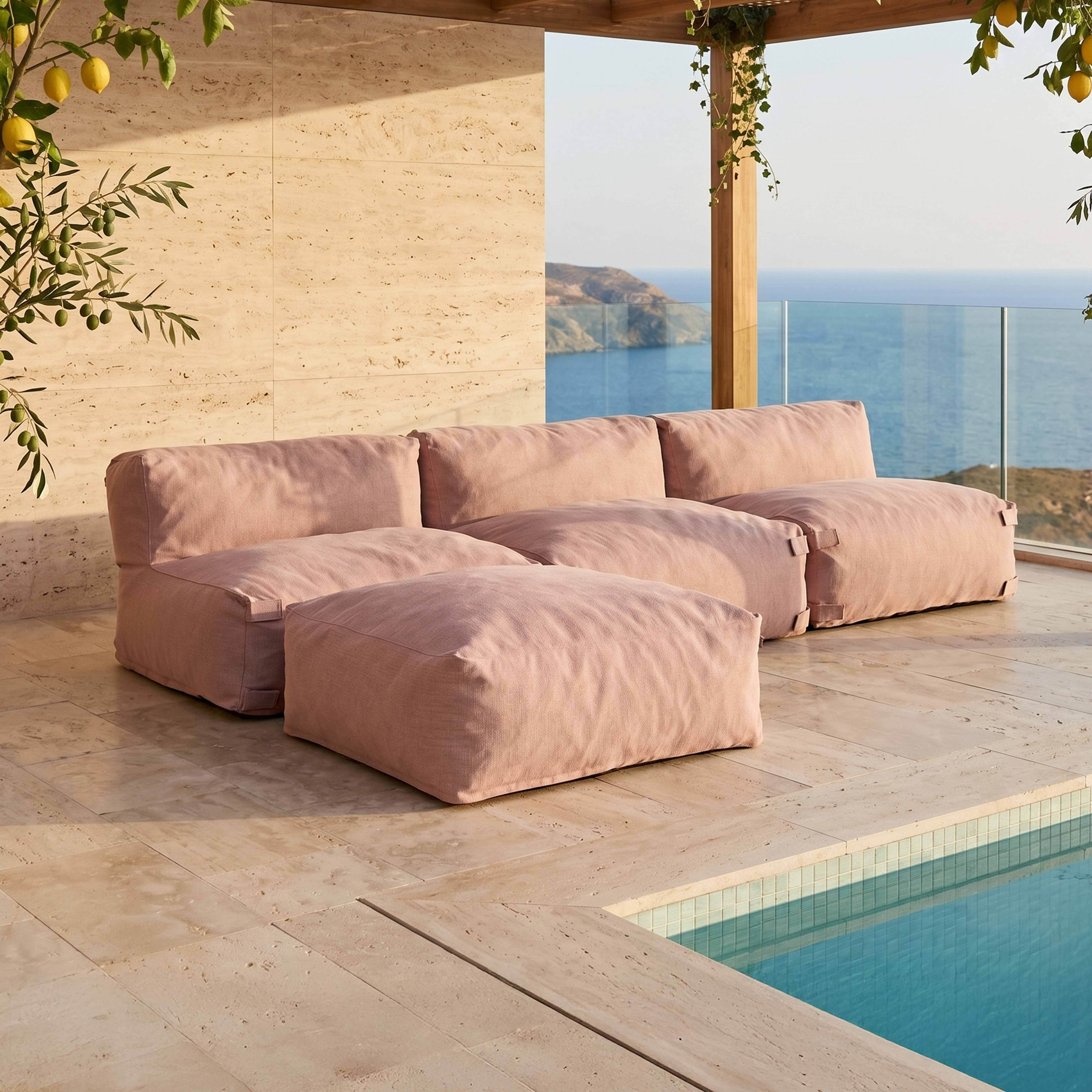 Rosa Lounge-Möbel am Pool mit Blick auf das Meer, Zitronenbaum im Vordergrund.
