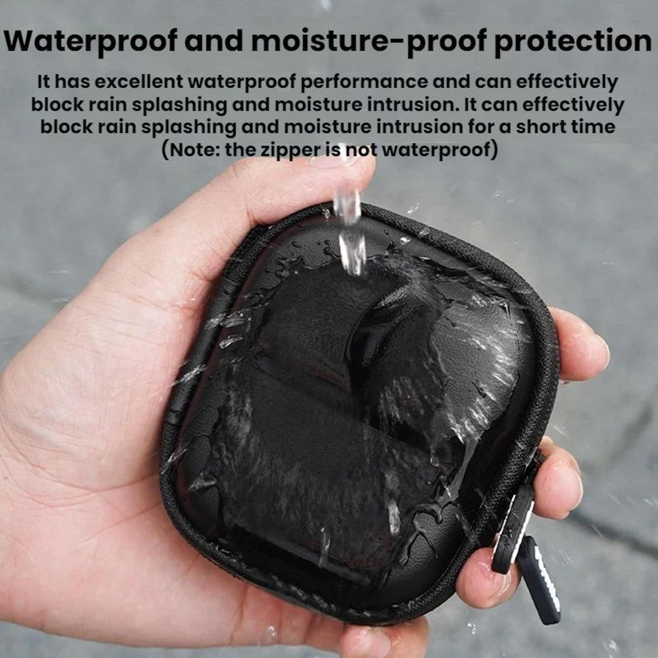 Schwarze Tasche wird mit Wasser bespritzt, die von einer Hand gehalten wird.