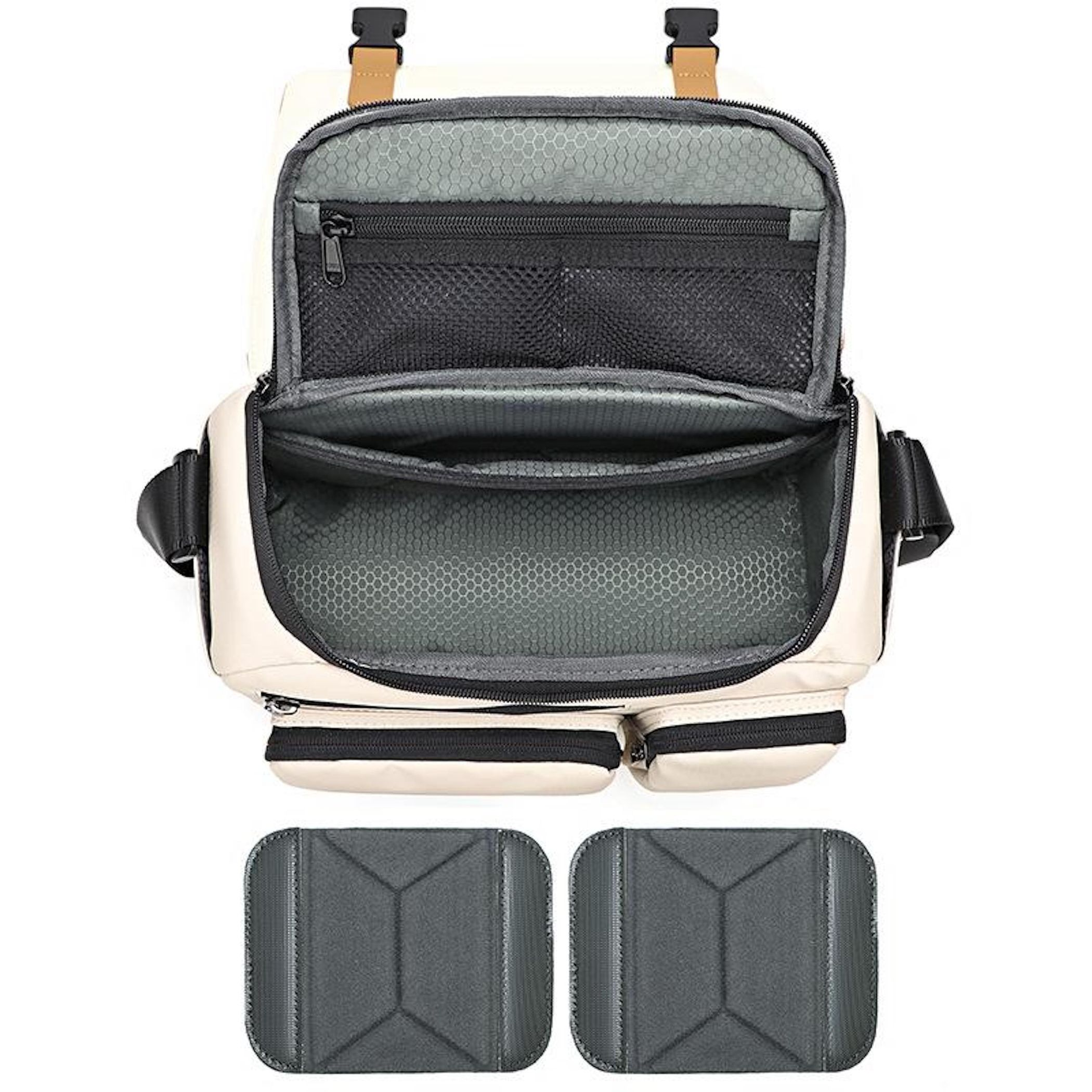 Eine beige Tasche ist geöffnet und zeigt Innenfächer. Zwei graue Polster liegen darunter.