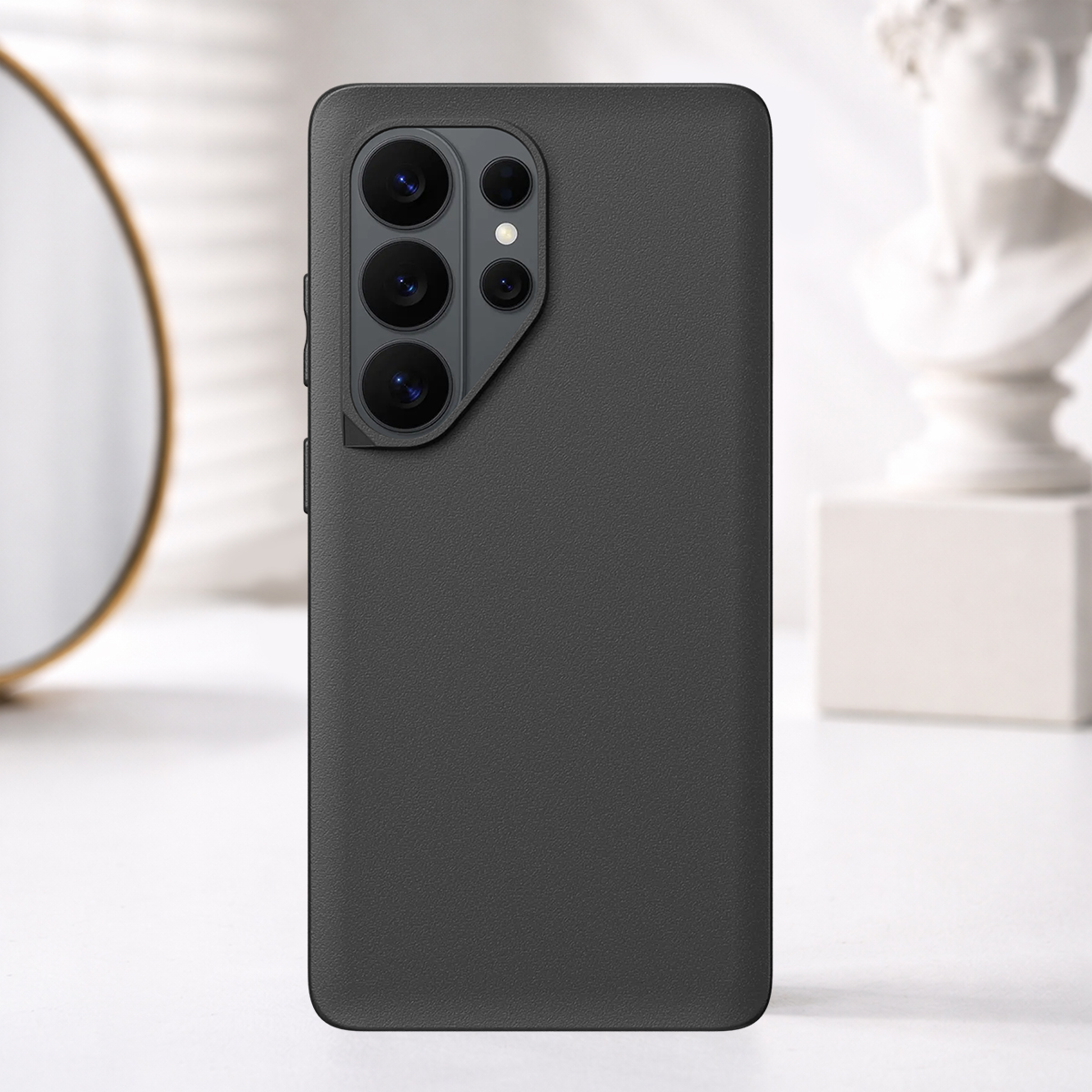 Smartphone grigio scuro con quattro fotocamere sul retro, posto su un tavolo.
