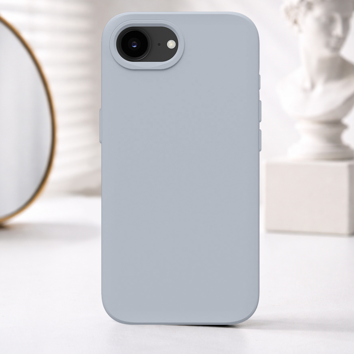 Una cover grigio chiaro per telefono con ritaglio fotocamera, davanti a specchio e busto.