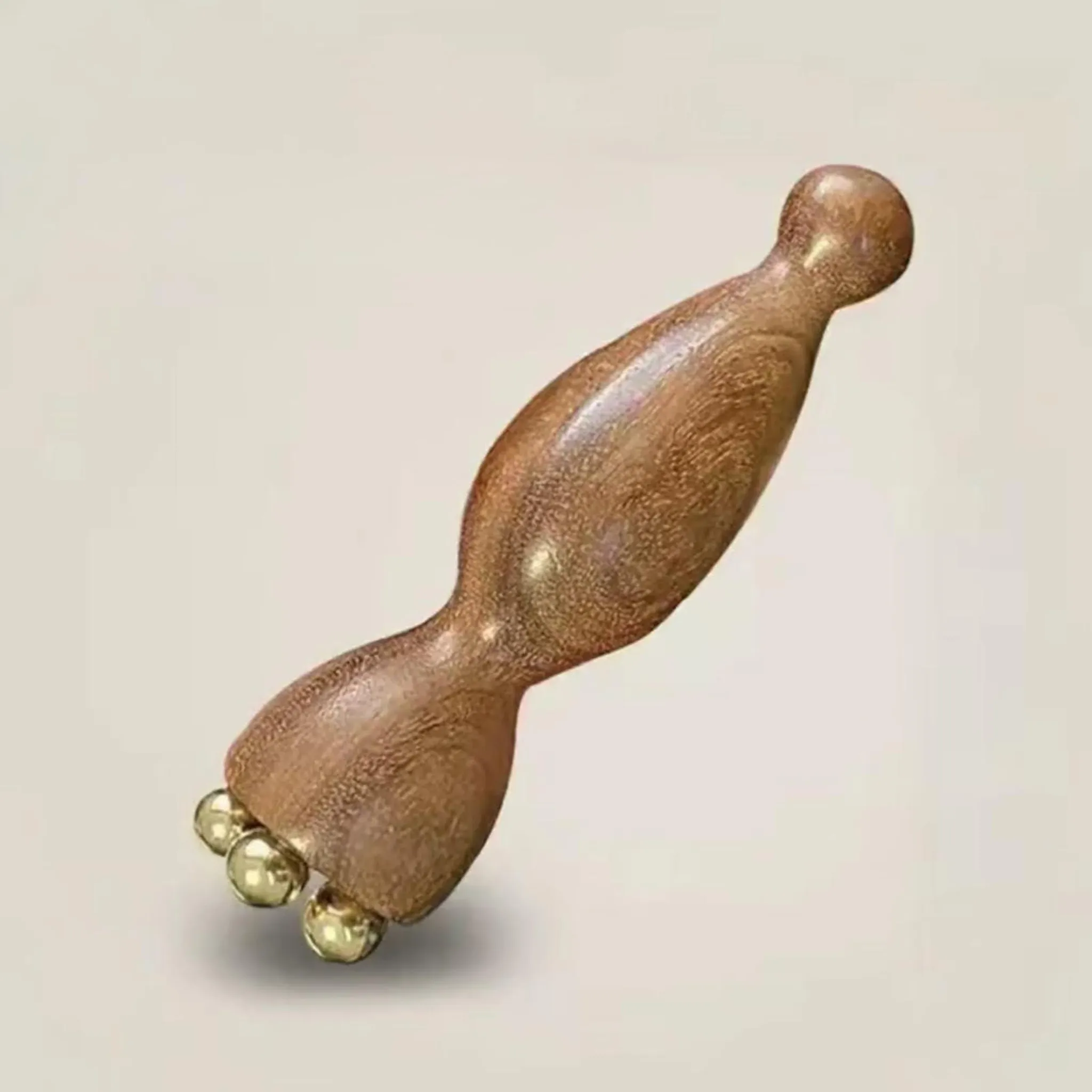 Ein hölzerner Massagegriff mit drei goldenen Kugeln an einem Ende.