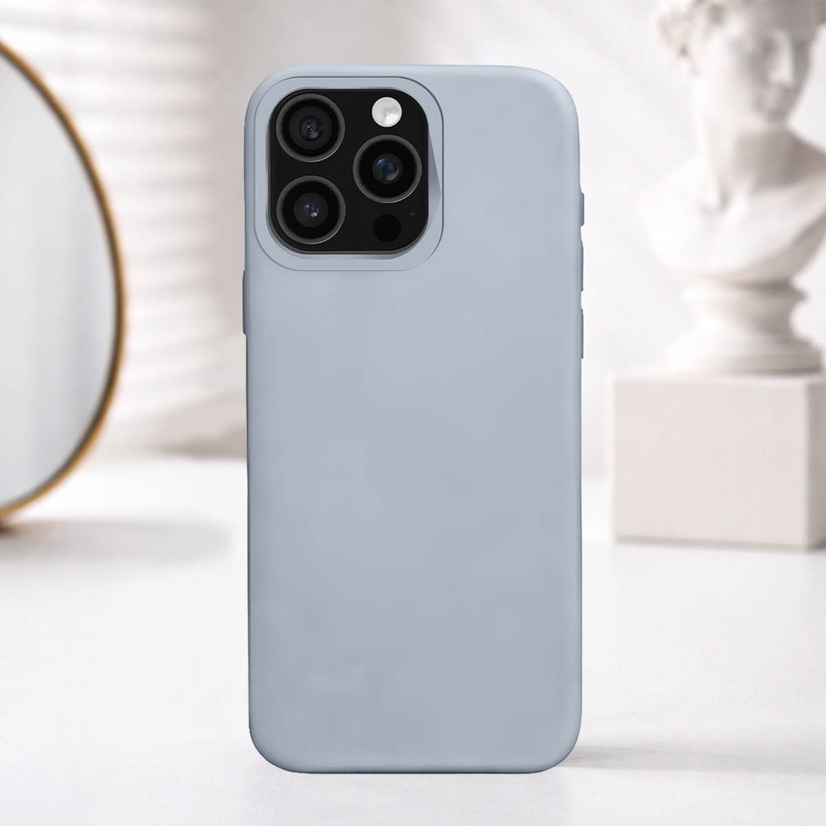 Una cover per telefono azzurra con tre fotocamere su un tavolo bianco.