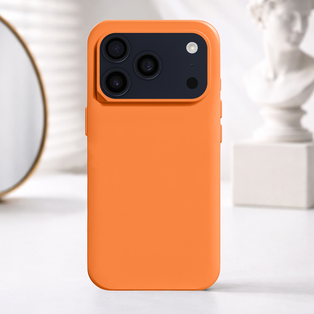 Orange Handyhülle mit drei Kameralinsen und Blitz auf einem Tisch.