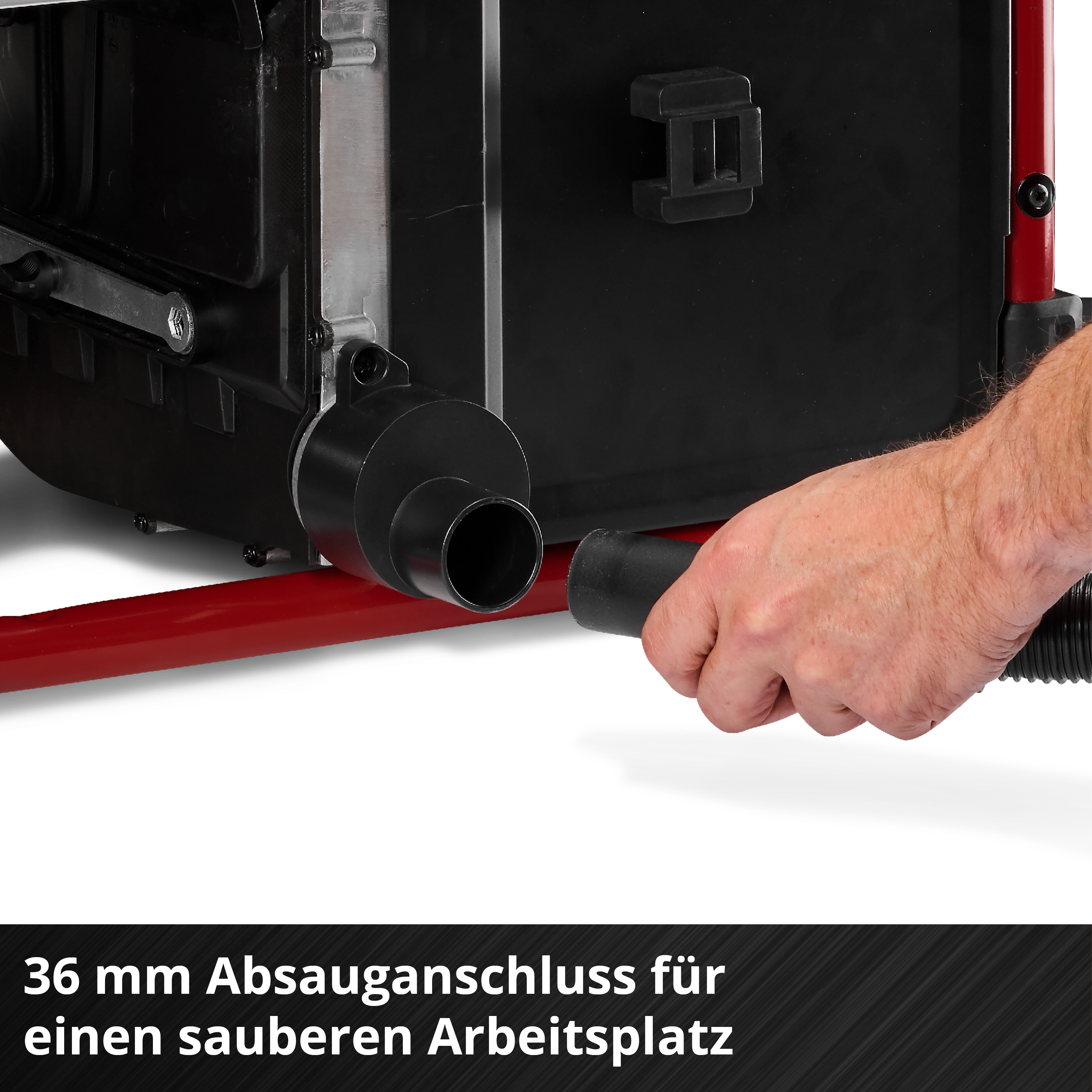 Ein Mann verbindet einen Schlauch mit einem 36mm Absauganschluss an einer Maschine.