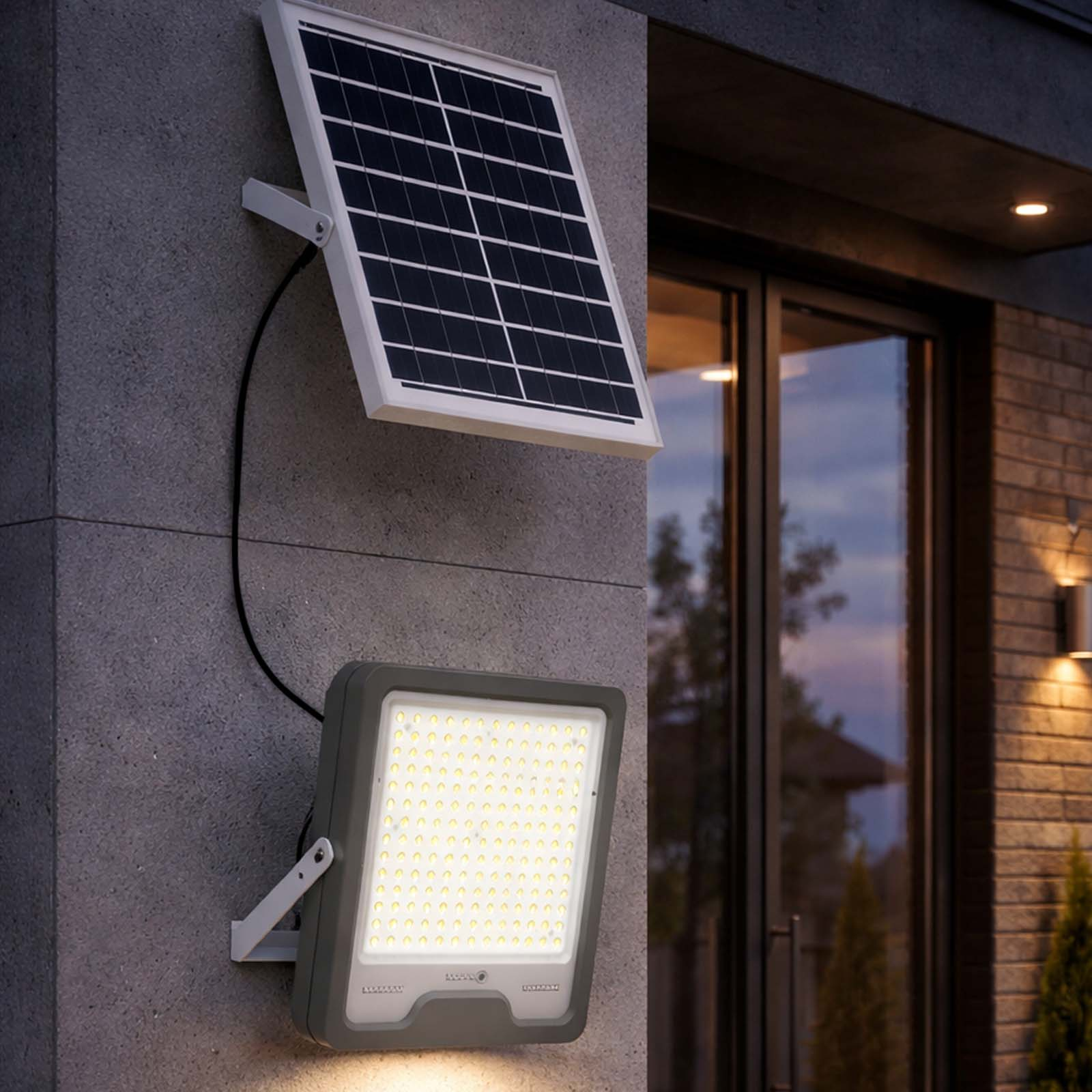 Solarpanel und heller LED-Strahler an einer Betonwand montiert.