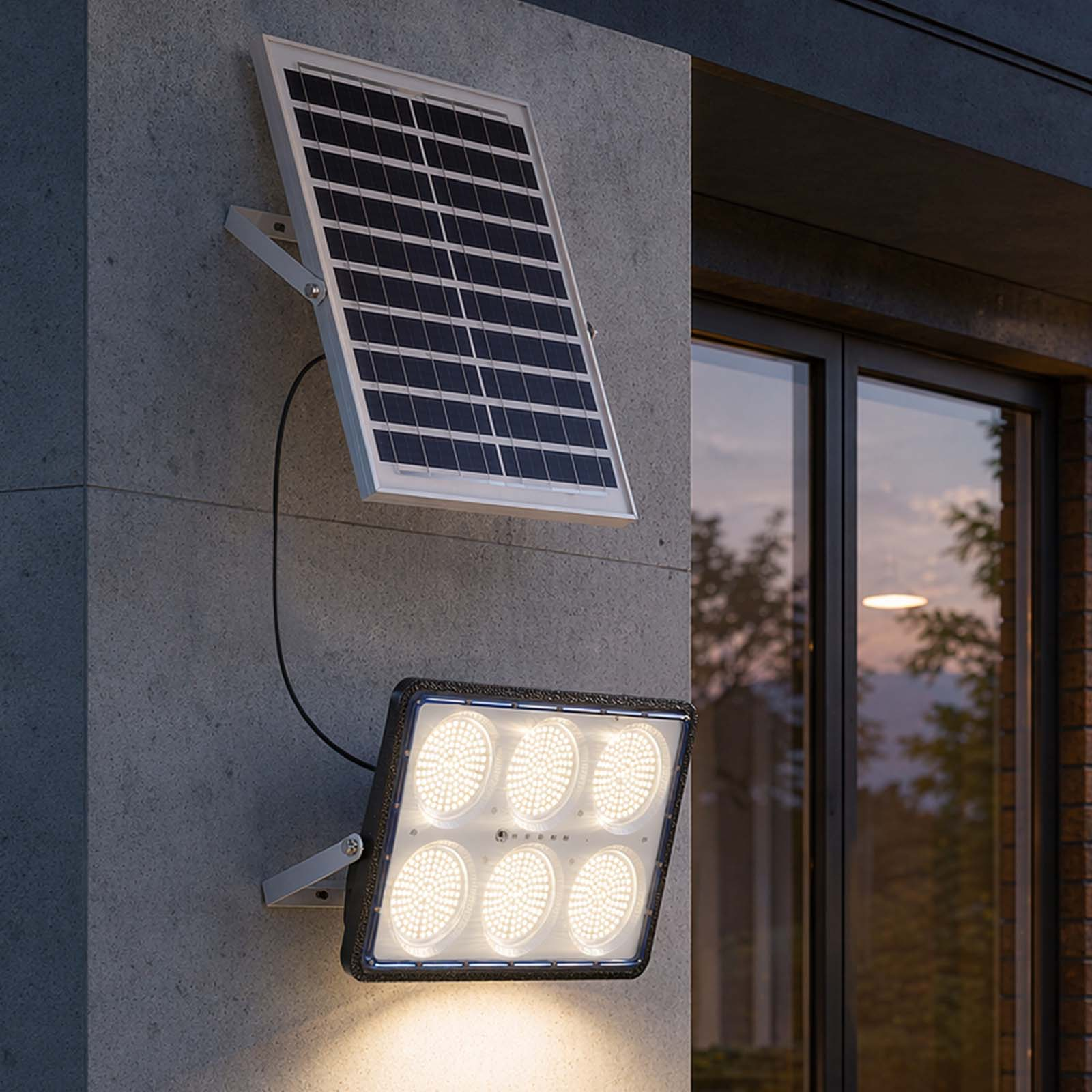 Solarpanel und Flutlicht an grauer Wand montiert. Fenster daneben.