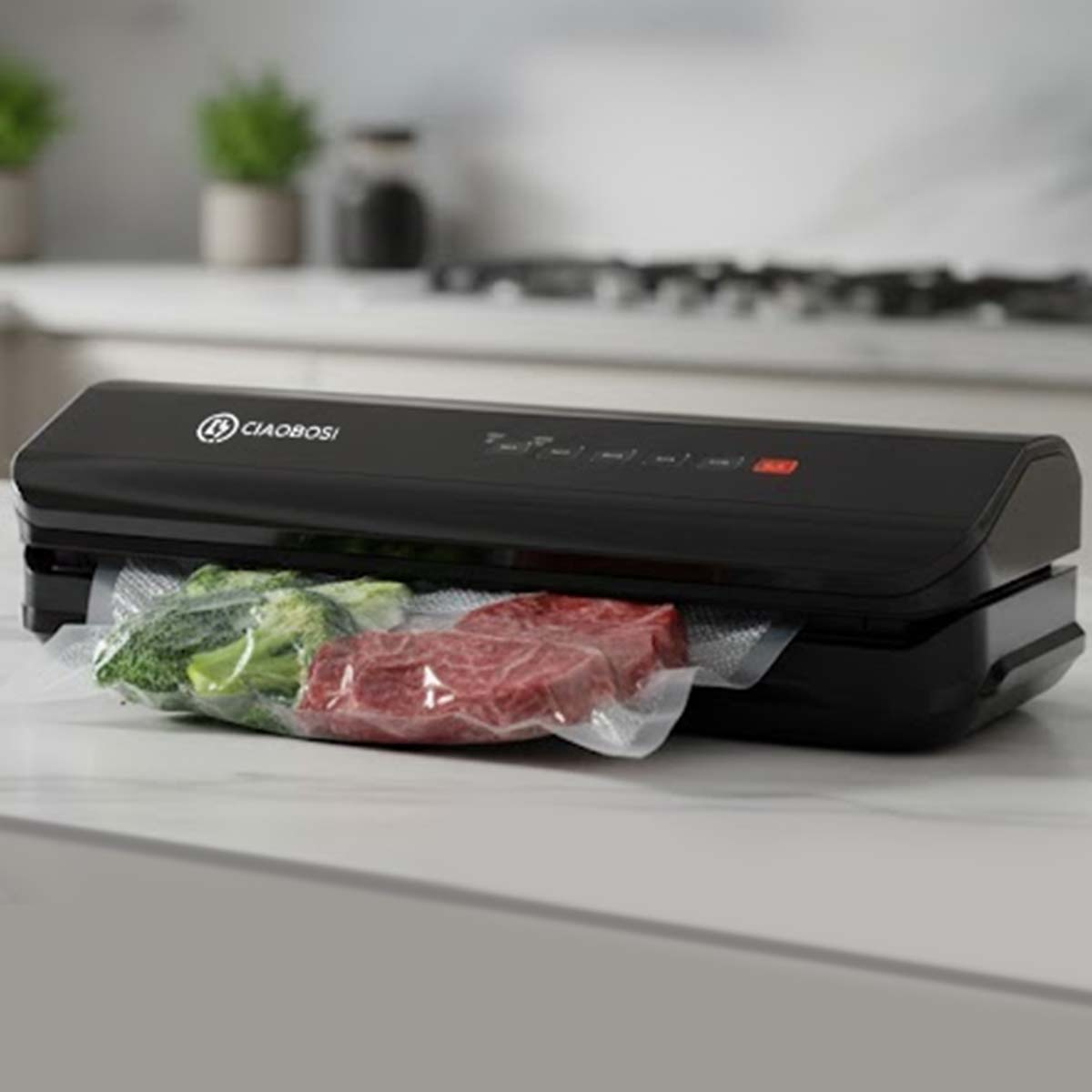 Schwarzer Vakuumierer mit Fleisch und Brokkoli in versiegelten Beuteln.