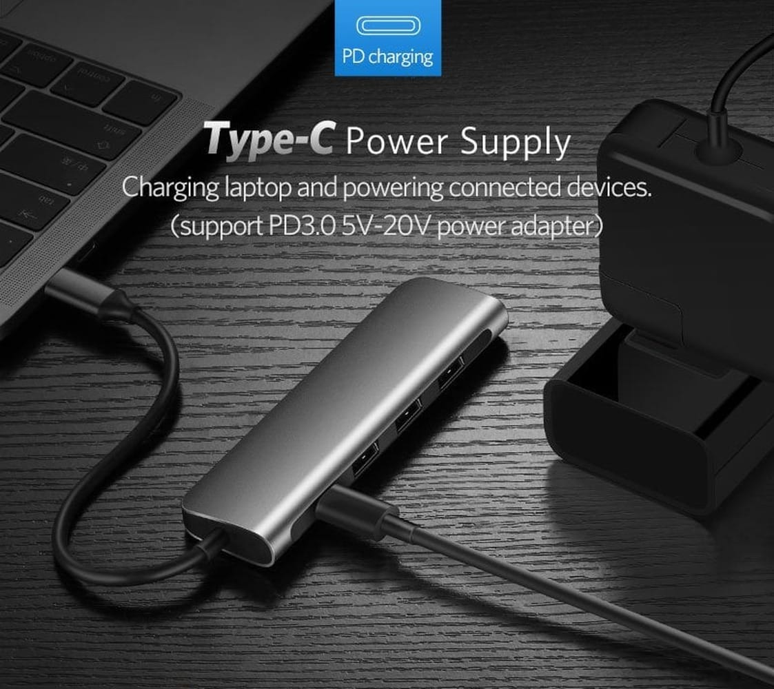 Gray USB-C hub charges laptop and powers devices. PD charging.