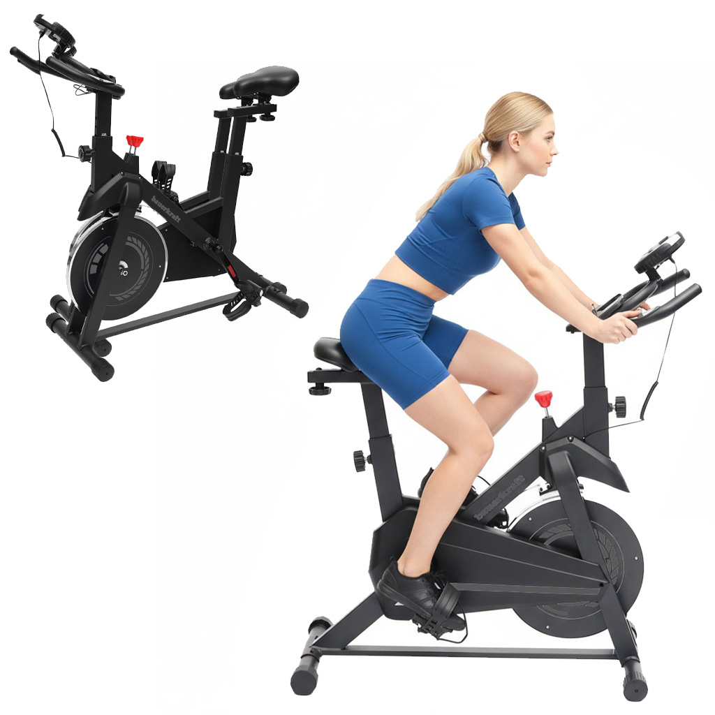 Kobieta w niebieskim stroju sportowym jedzie na czarnym rowerze stacjonarnym. Drugi rower po lewej.