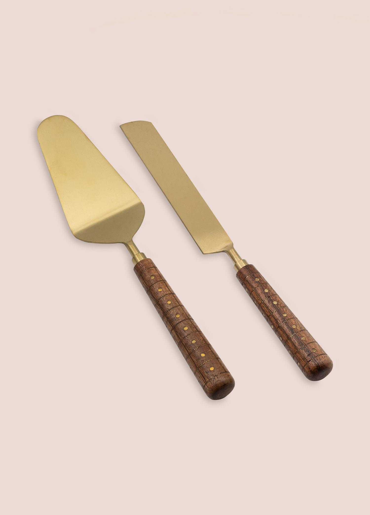 Ahşap saplı altın rengi pasta spatulası ve bıçağı açık zeminde.