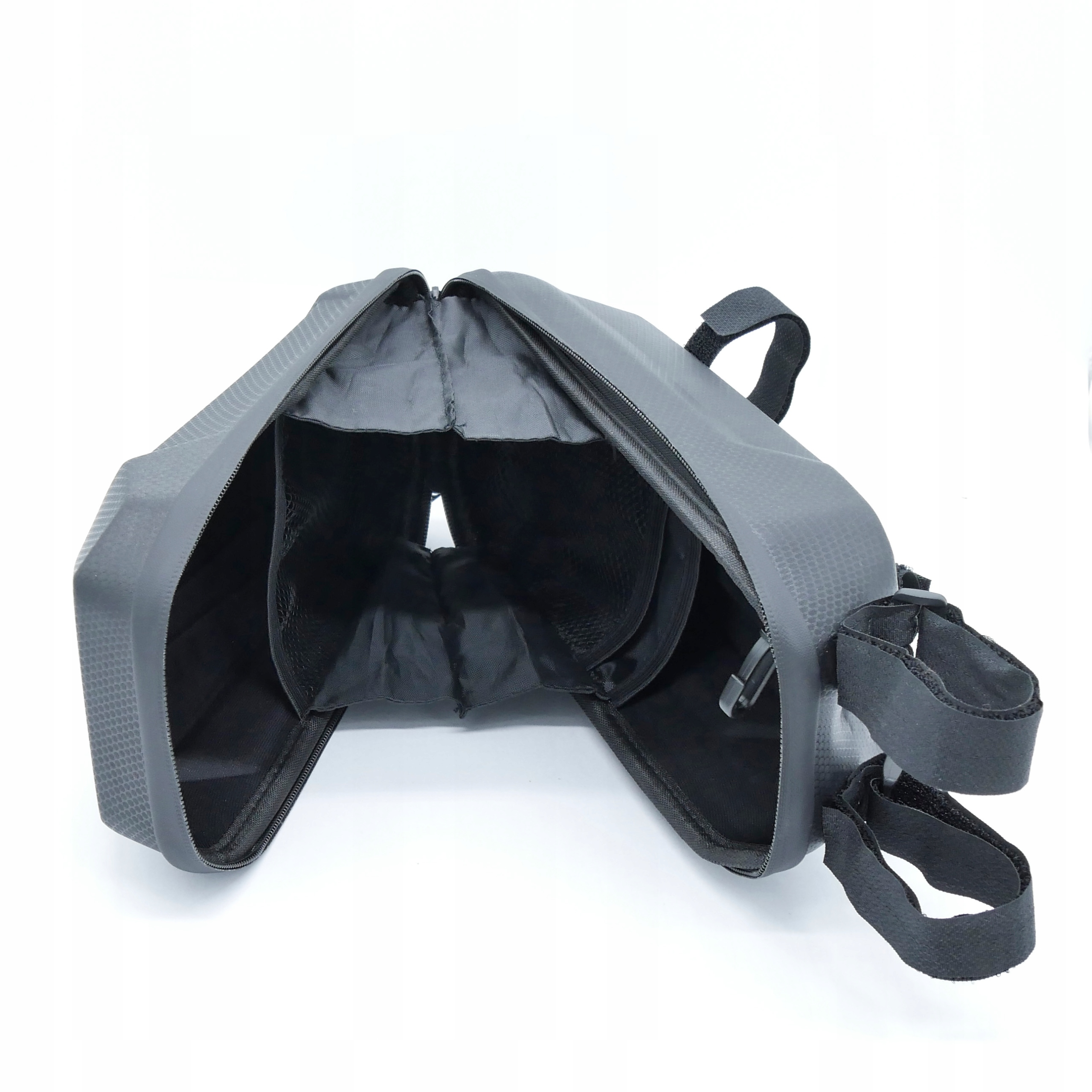Una borsa nera aperta con cerniera e cinghie su sfondo bianco.