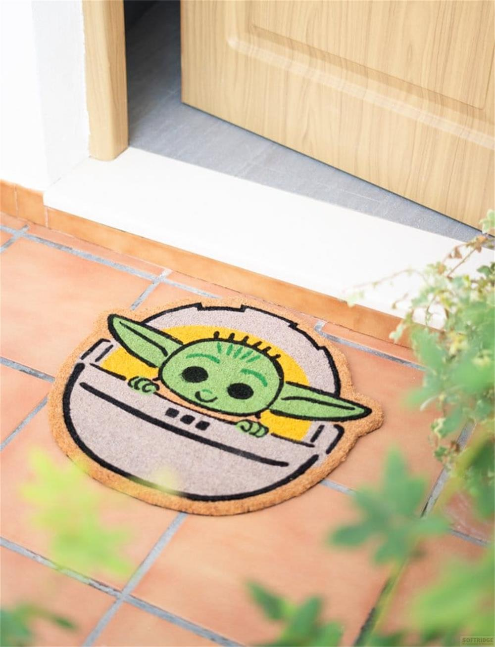 Tappetino con Baby Yoda che sbuca da un pod, posizionato su piastrelle di terracotta.