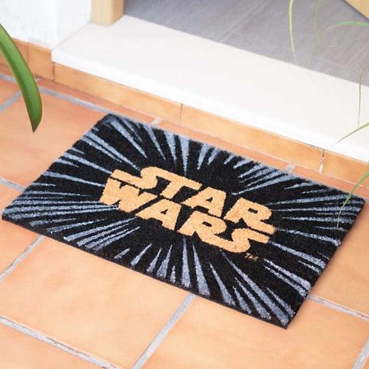 Uno zerbino nero con il logo giallo di Star Wars e linee raggianti.