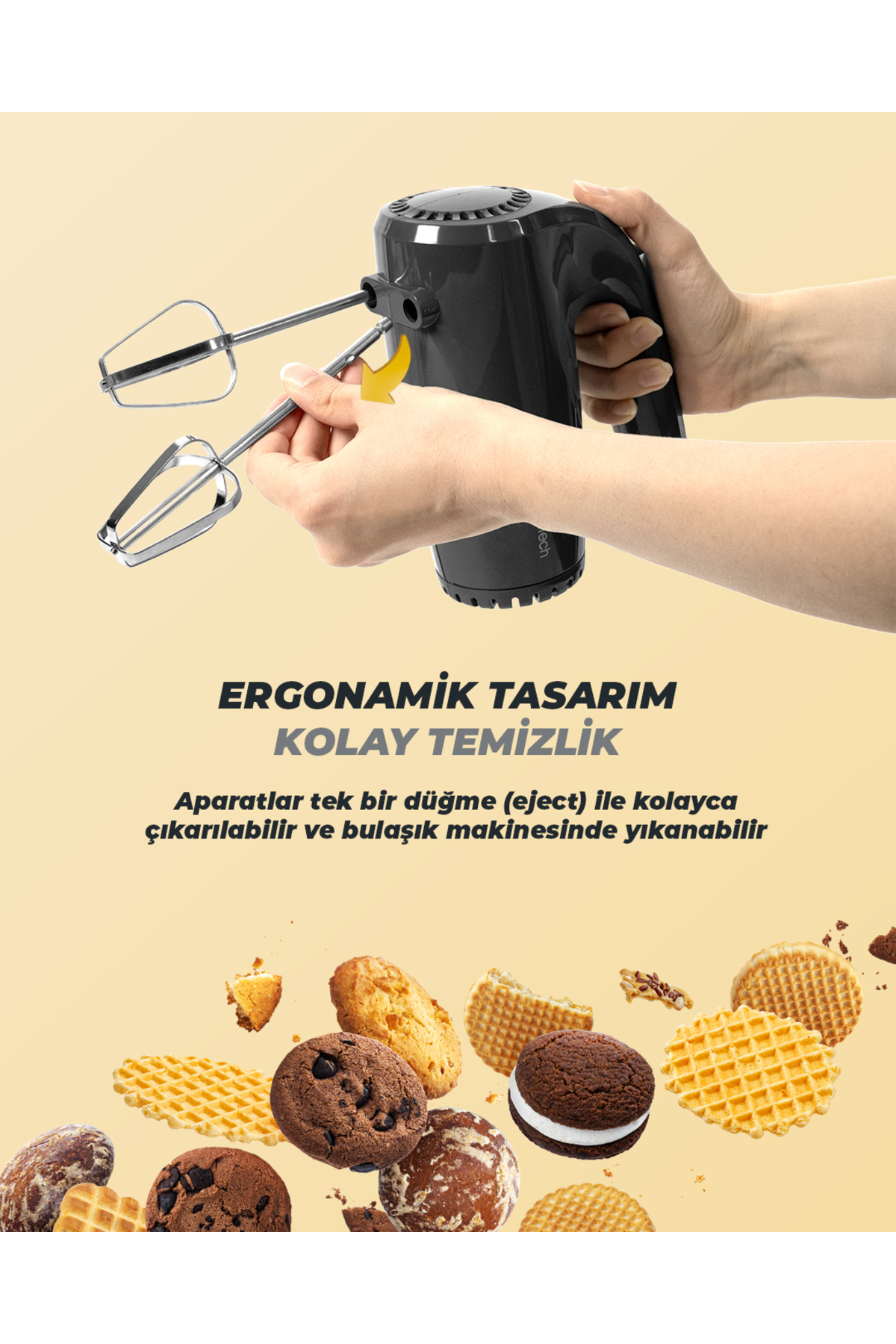 Siyah el mikseri, çıkarılabilir çırpıcıları ve etrafındaki kurabiyeler.