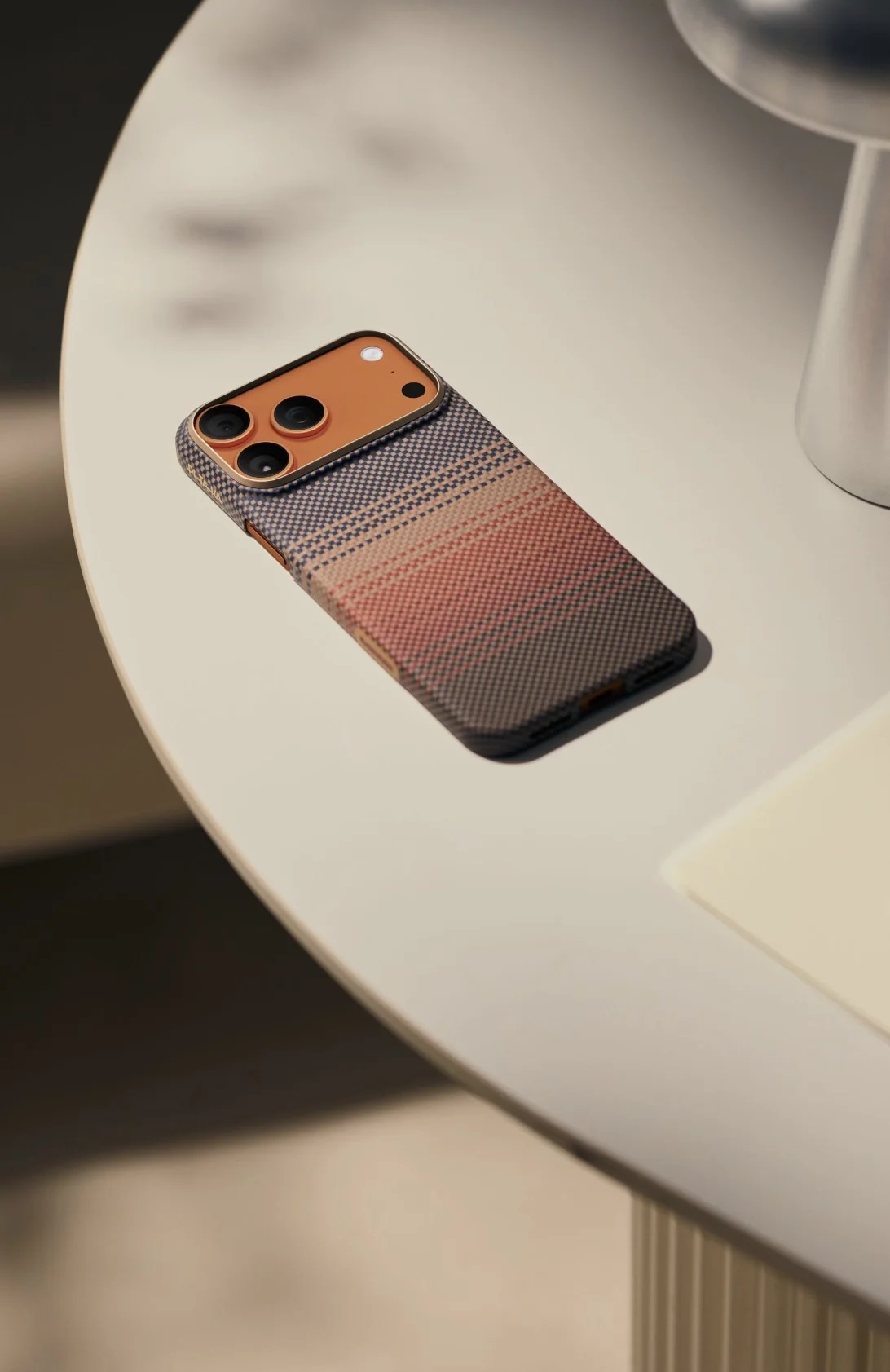 Una cover per iPhone fantasia giace su un tavolo. Parte del dispositivo è visibile.