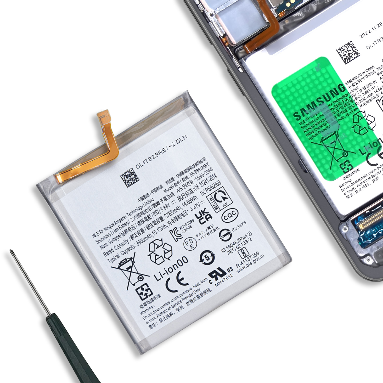 Una batteria per smartphone con logo Samsung e dettagli tecnici accanto a uno strumento.