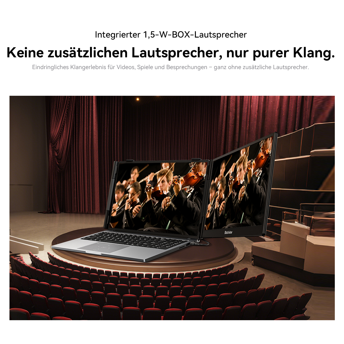 Laptop mit zwei Bildschirmen in einem Theatersaal zeigt ein Orchester.