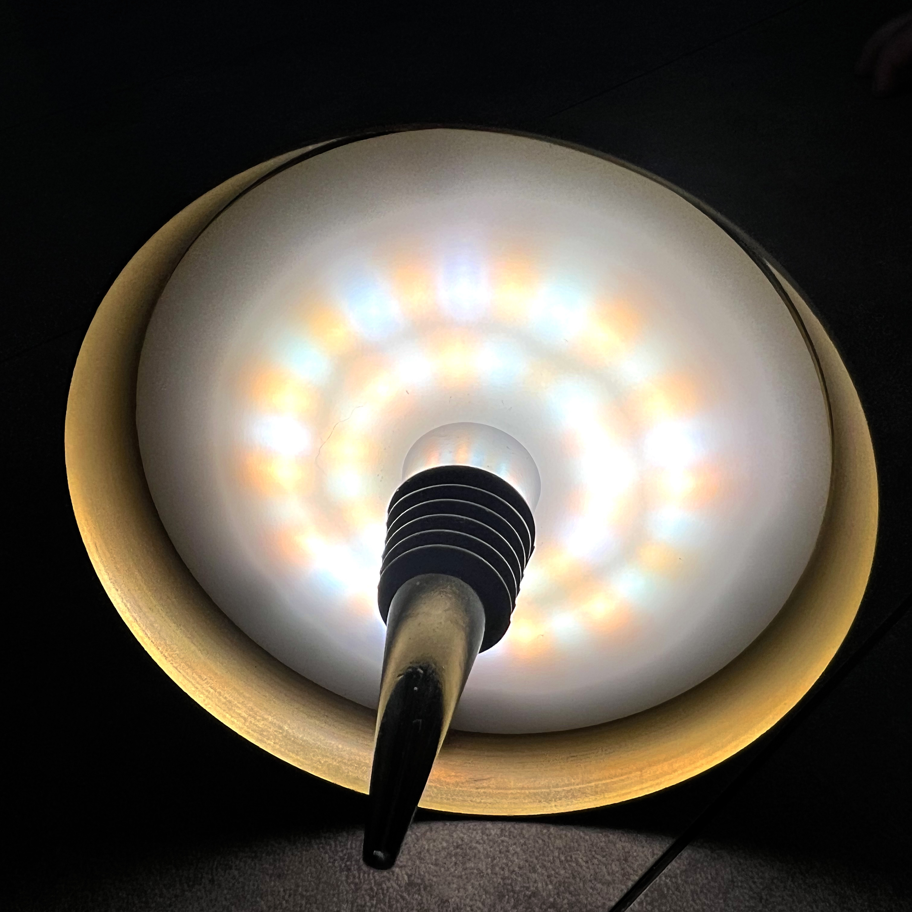 Eine Lampe mit LED-Licht und goldenem Rand leuchtet im Dunkeln.