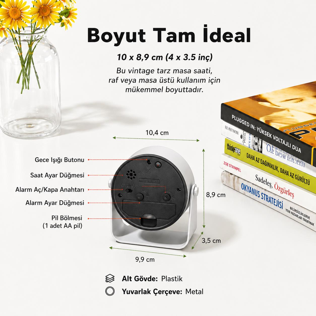 10x8,9 cm boyutlarında beyaz bir çalar saat, sarı çiçekli bir vazo ve kitaplar.