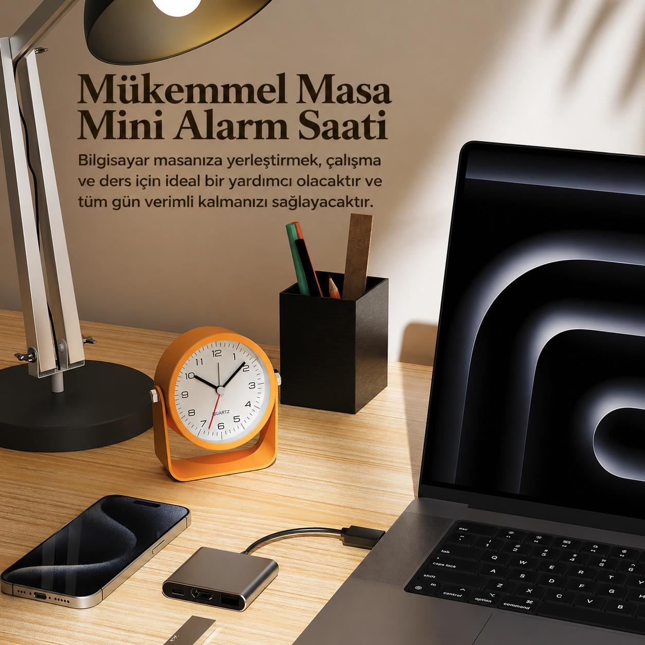 Laptop, telefon, çalar saat ve aksesuarların olduğu masa.
