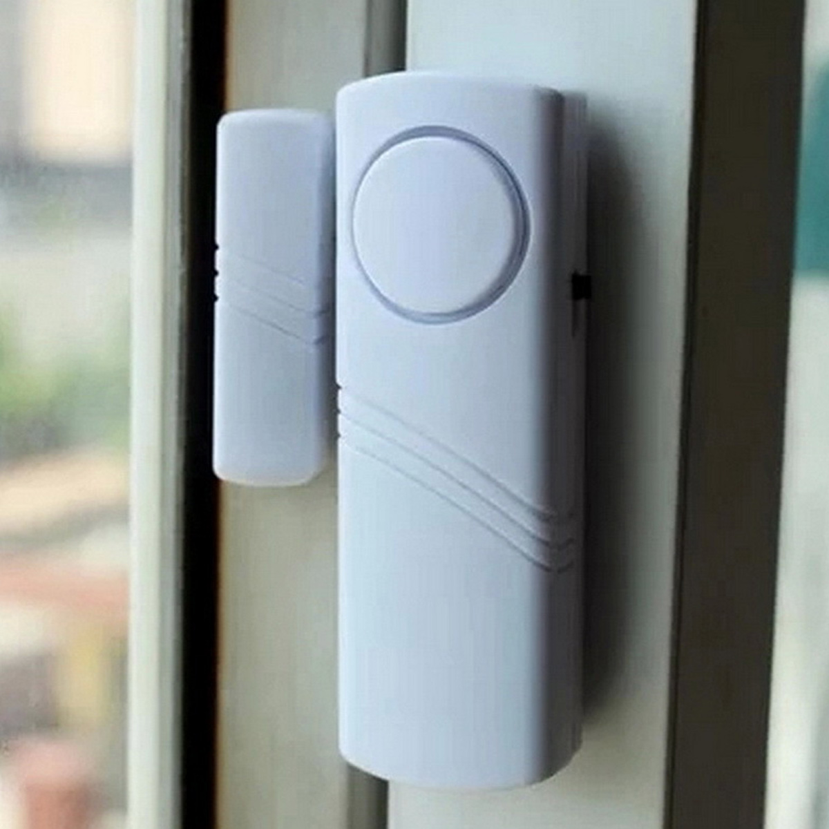 Ein weißer Tür-/Fensteralarm mit zwei Teilen, die an einem Rahmen befestigt sind.