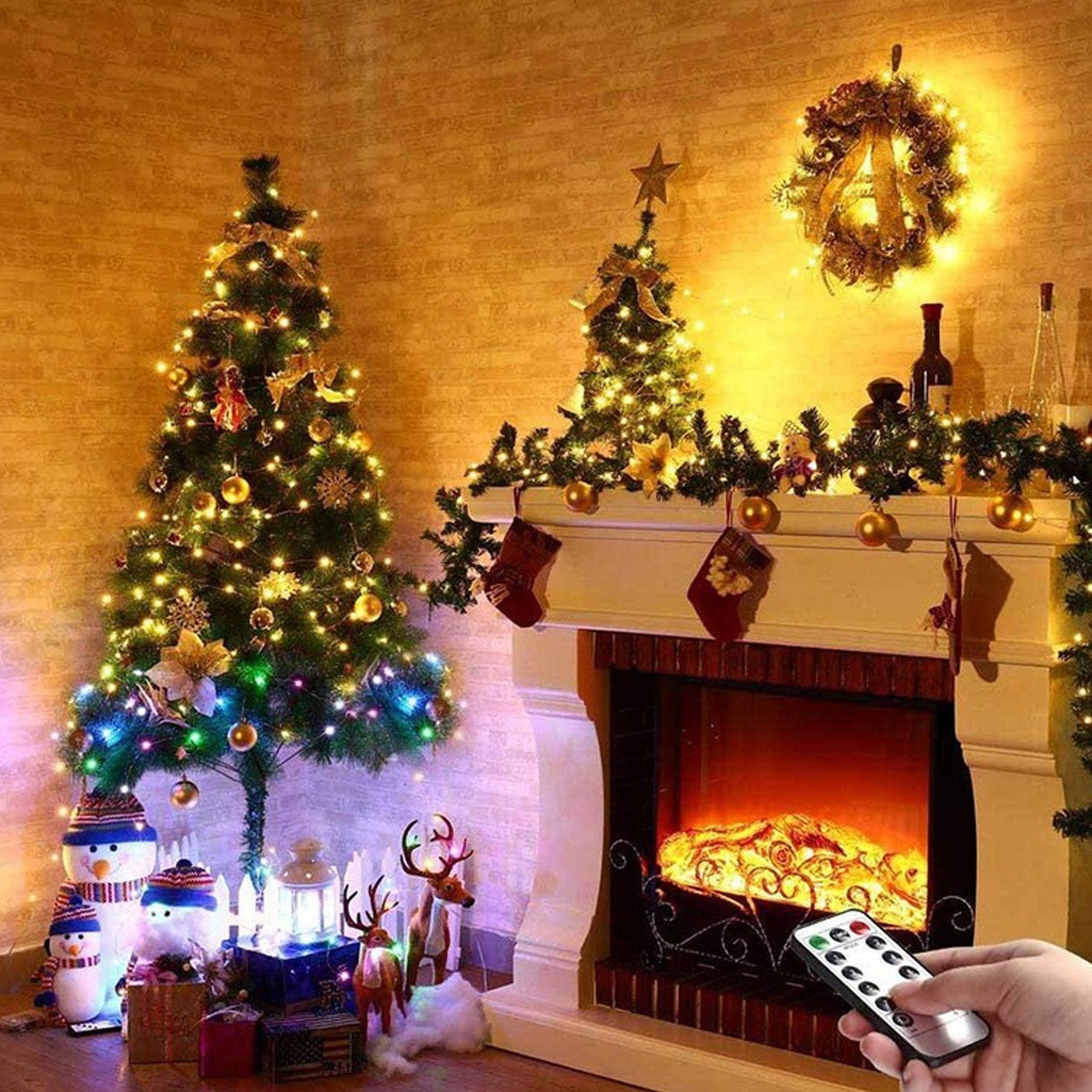 Festlich geschmückte Weihnachtsbäume und ein Kamin mit Fernbedienung.