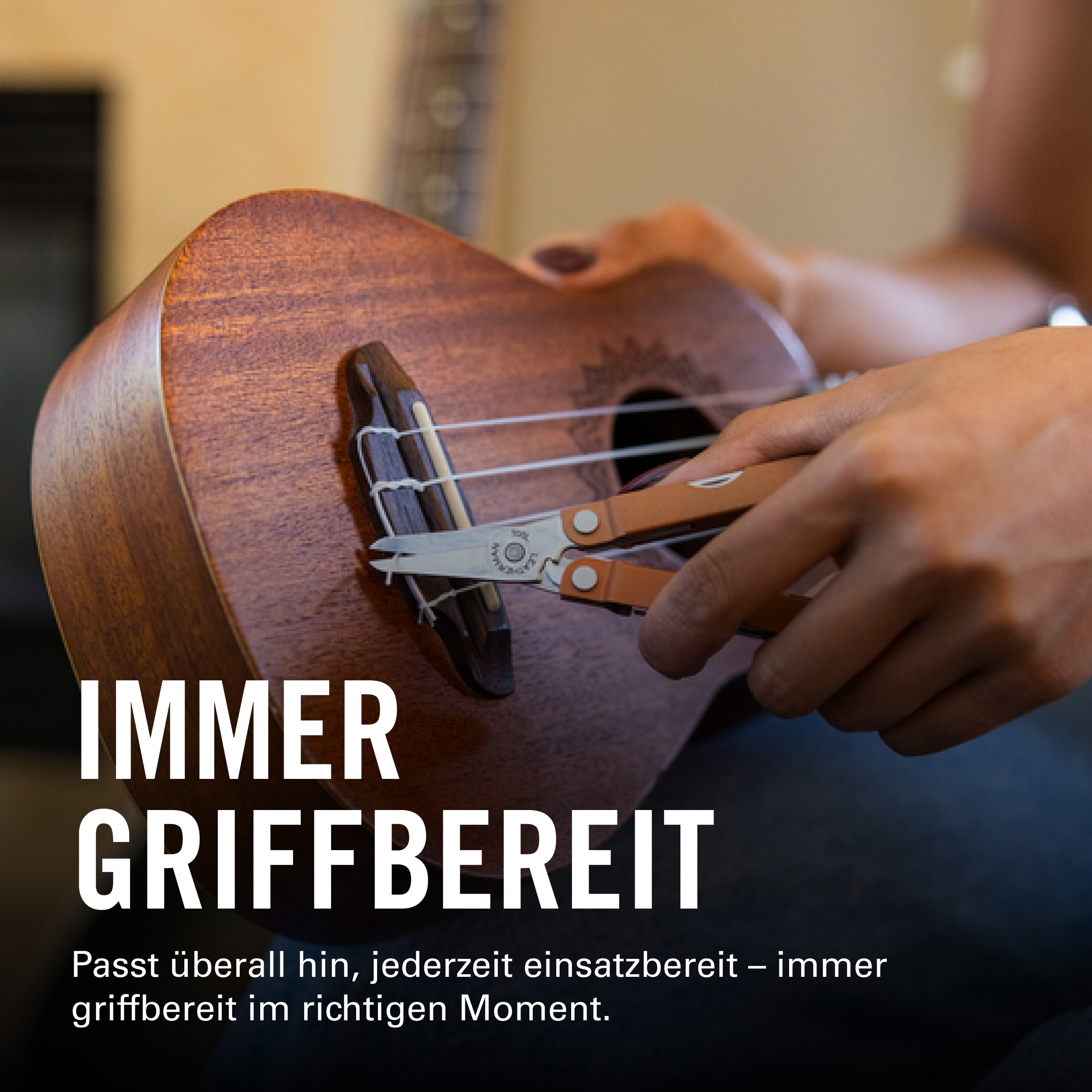 Person schneidet Saiten einer Ukulele mit einem Multitool.