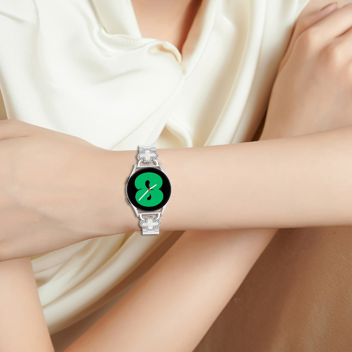 Eine Frau trägt eine Smartwatch mit silbernem Armband und einem grünen Zifferblatt.
