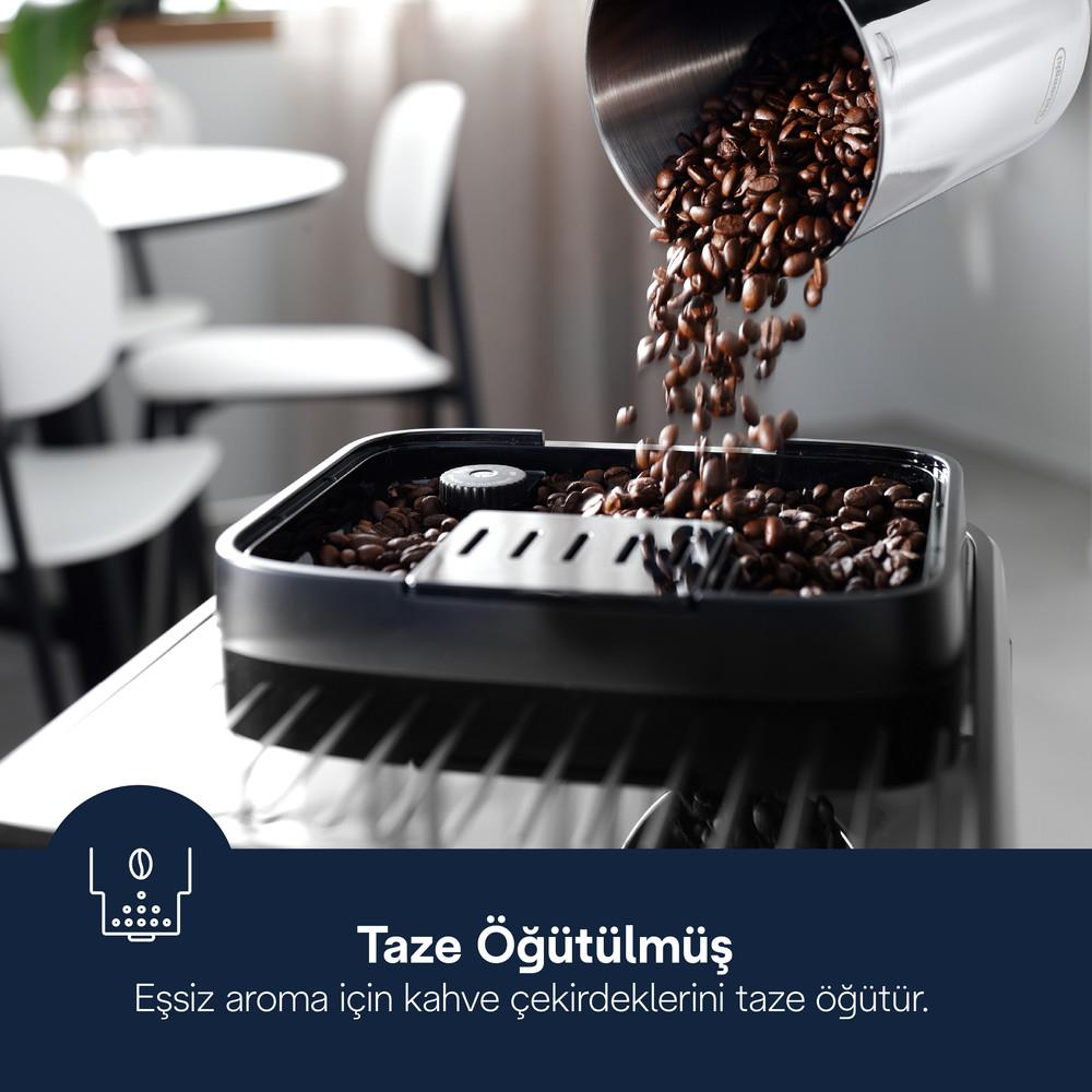 I chicchi di caffè vengono versati da un contenitore di metallo in una macchina da caffè.