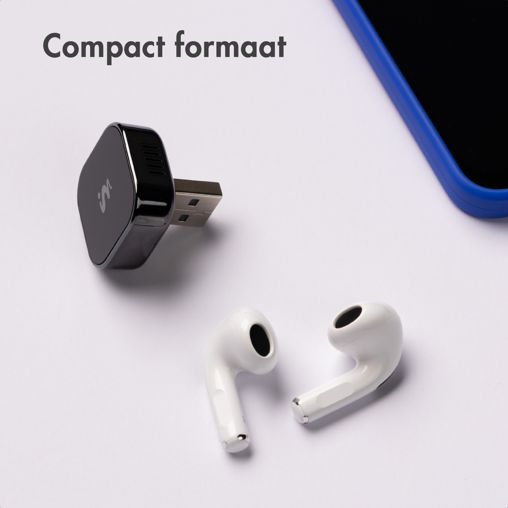 Black USB adapter next to white earbuds and a blue mobile phone.