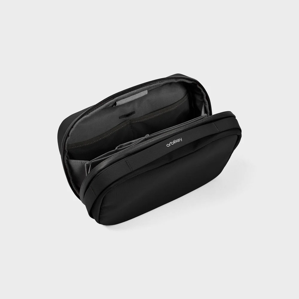 Czarna torba z otwartą przegrodą i kieszeniami, widoczne logo Orbitkey.