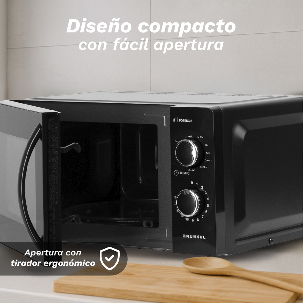 Microondas negro con puerta abierta, cuchara de madera sobre tabla de cortar.