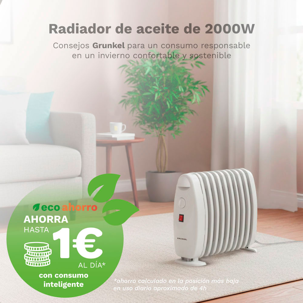 Un radiador de aceite blanco está sobre una alfombra, junto a un sofá y una planta.