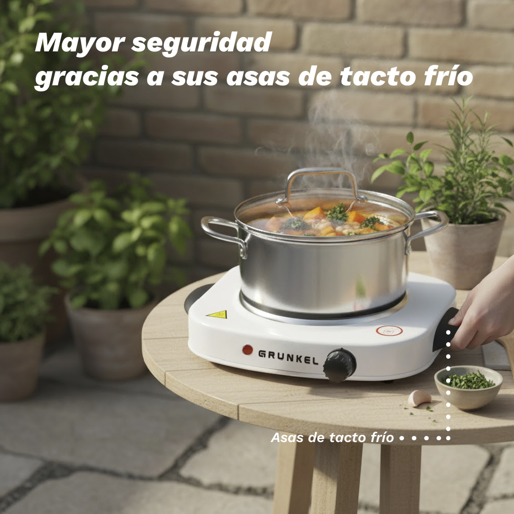 Una olla de comida se cocina en una placa caliente blanca sobre mesa de madera.
