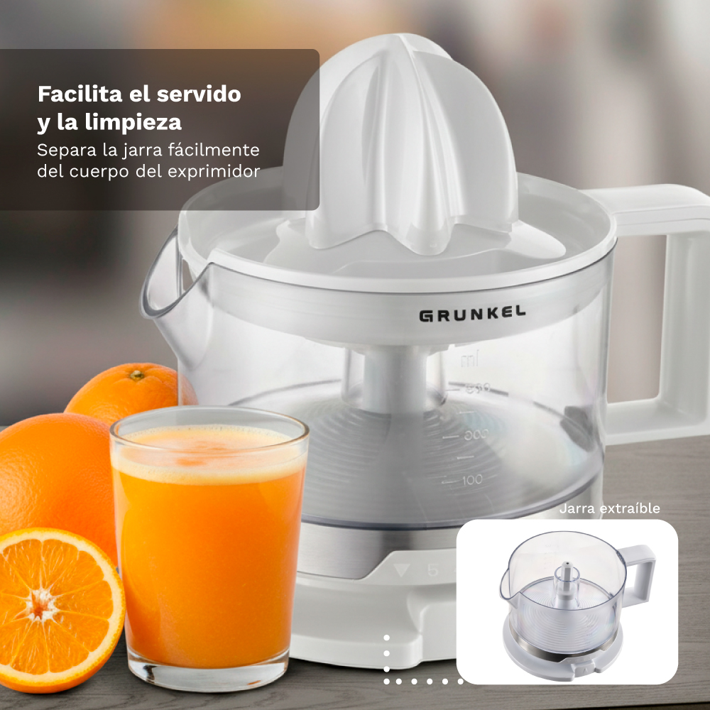 Un spremiagrumi elettrico bianco con un bicchiere di succo d'arancia accanto.