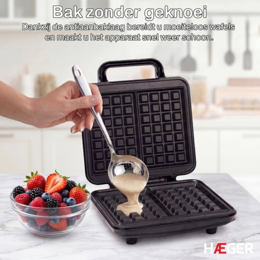 A hand pours batter from a ladle into an open waffle maker.