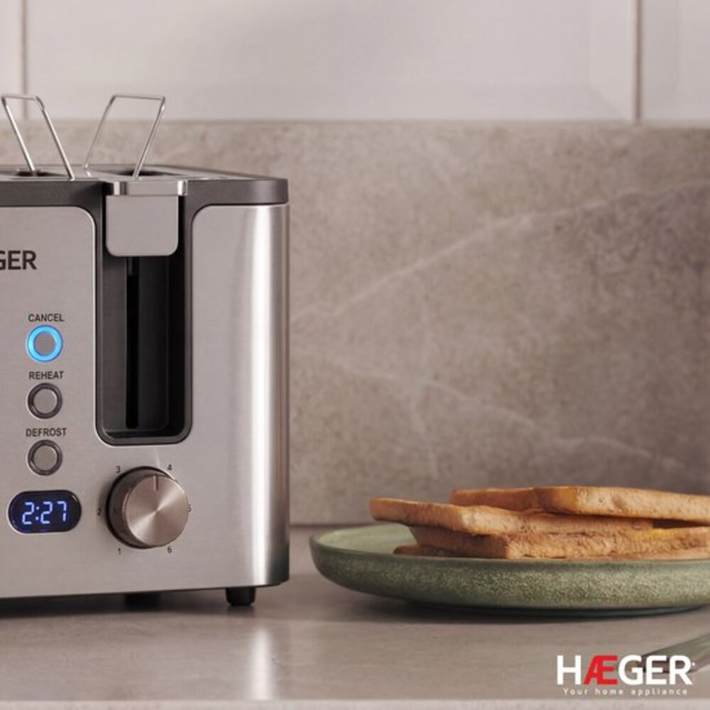 A silver toaster with toast on a green plate.