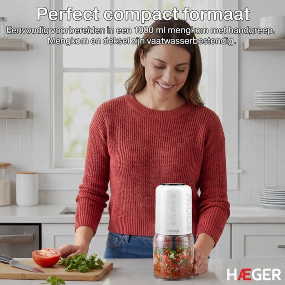 A woman in a kitchen uses a white mini chopper with a glass bowl.