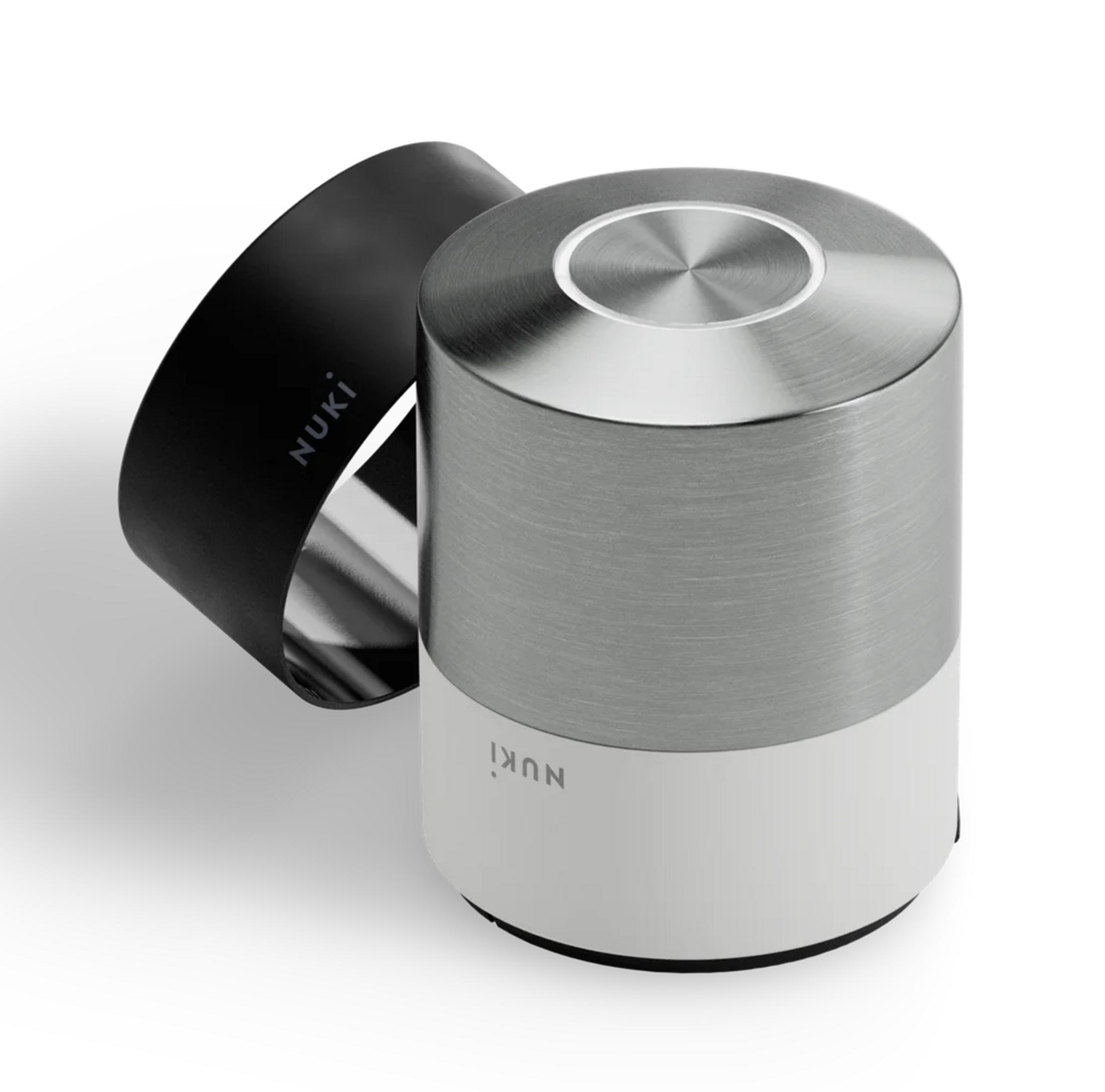 Ein Nuki Smart Lock Zylinder mit einem schwarzen Armband, auf weißem Hintergrund.
