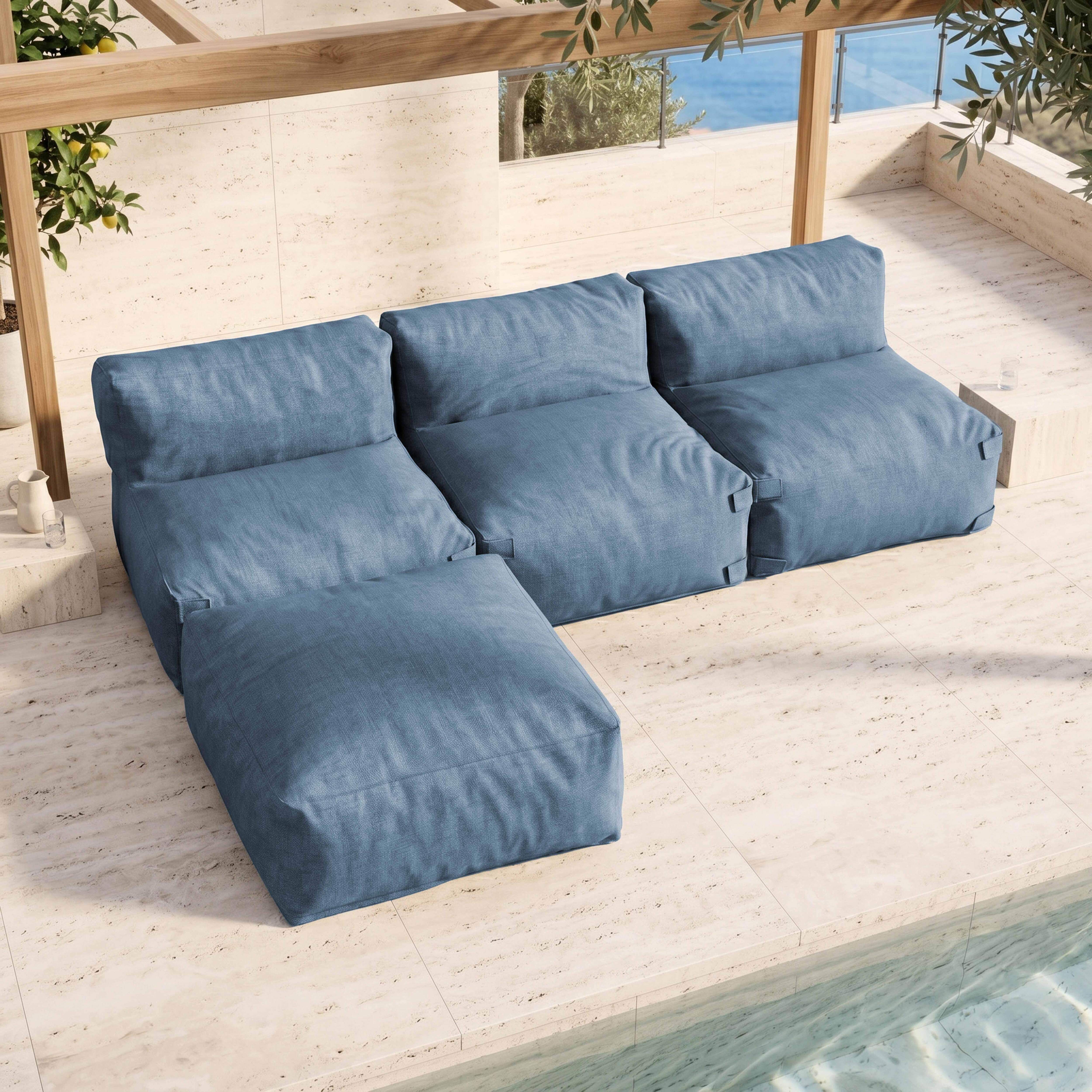 Blaue Outdoor-Loungemöbel auf beigefarbener Terrasse mit Pool und Pflanzen.